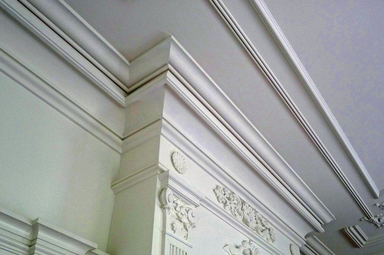 Klassieke kroonlijst met decoratief stucwerk langs de wand