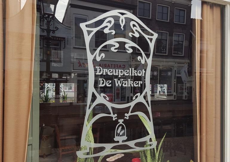 Decoratief raamlogo ontworpen voor De Waker